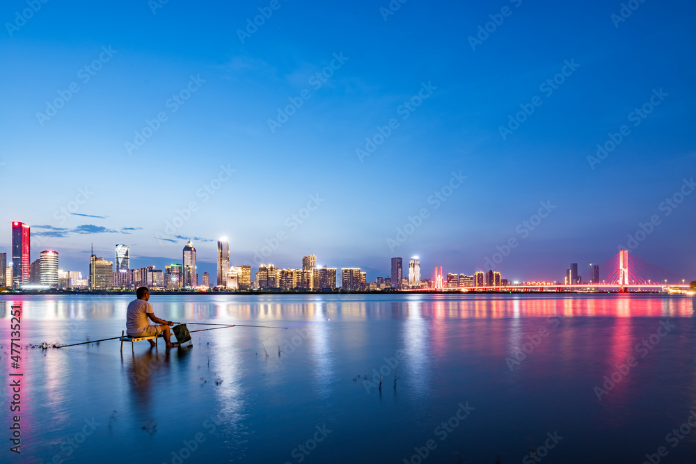 Fishing man and cityscape in the city river