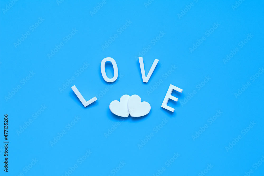 two white hearts and the word LOVE made of white letters on a blue clean background two white hearts and the word LOVE made of white letters on a blue clean background
