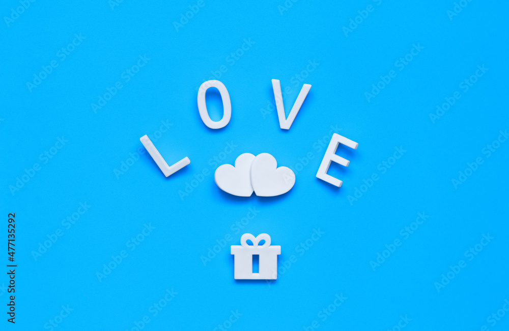 word LOVE, two hearts and a gift on a blue background word LOVE, two hearts and a gift on a blue background