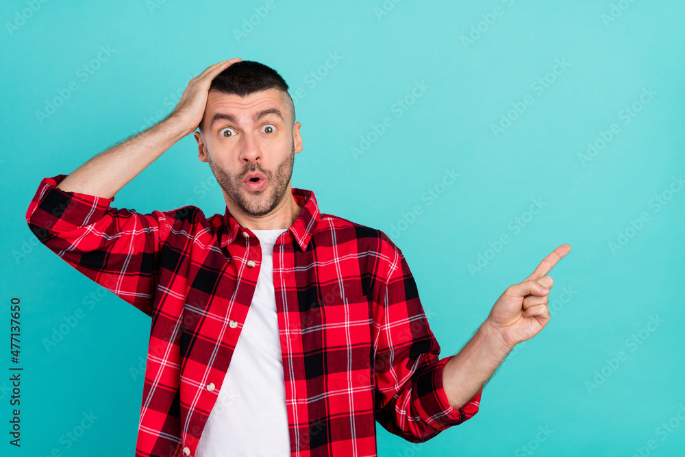 Photo of astonished shocked man point finger empty space sale news cool hand head isolated on teal color background Photo of astonished shocked man point finger empty space sale news cool hand head isolated on teal color background