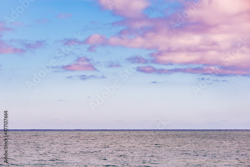 Pink clouds above the sea horizon at summer time.
