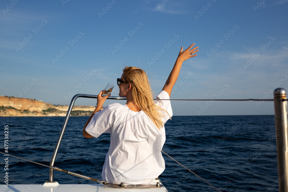 young woman drinking champagne on a yacht in the open sea young woman drinking champagne on a yacht in the open sea
