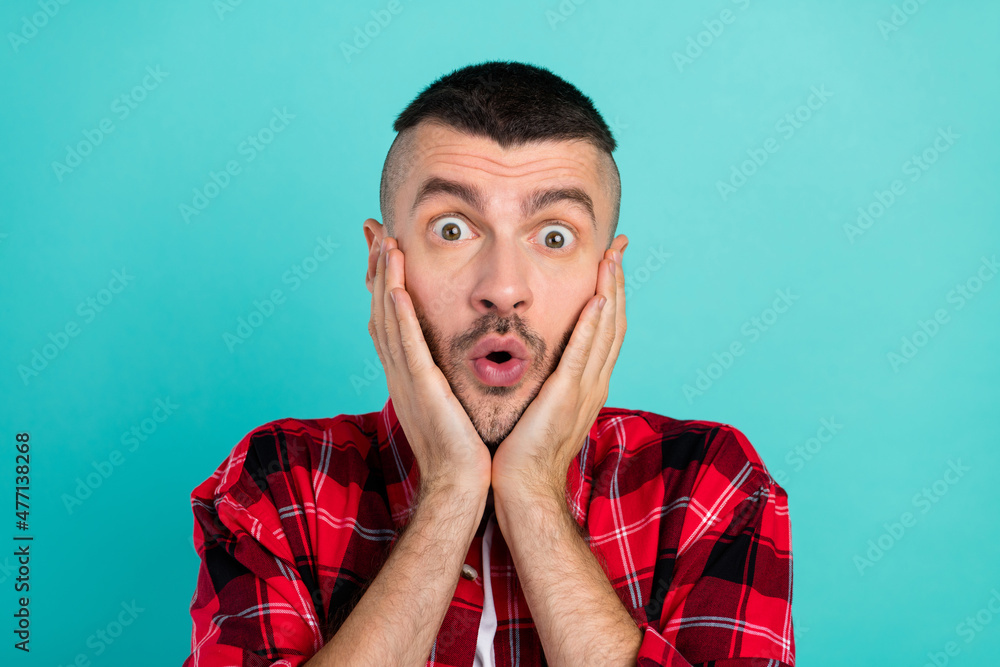 Photo of amazed shocked man hold hands face sale news reaction astonished isolated on teal color background Photo of amazed shocked man hold hands face sale news reaction astonished isolated on teal color background
