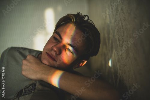 man with rainbow on eyes shadow and smiley nailpaint. LGBT concept. Teenagers problems, sad boy, skin problem. photo