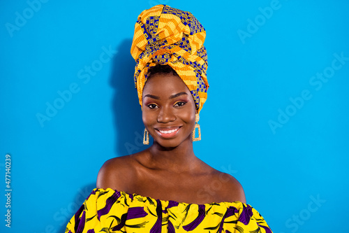 Portrait of charming cheerful dark skin girl beaming smile look camera isolated on blue color background