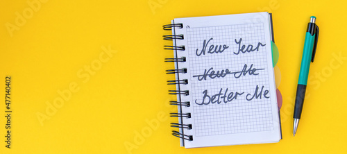 Valokuva banner with Writing in a notebook New year, better me on yellow background Happy new year quote