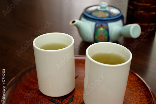 緑茶が注がれた二つの白いコップ