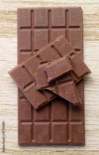 Top view of chocolate bars with chunks isolated on wooden backdrop