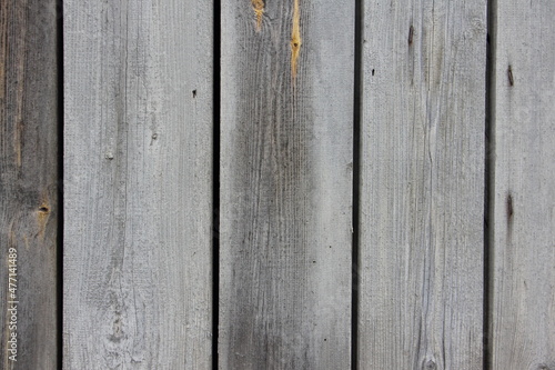 Old dry rural gray wooden wall surface closeup with a weathered vertical boards - vintage background texture