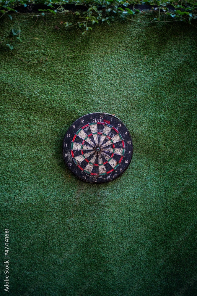 Darts hitting the bullseye of a dart board background