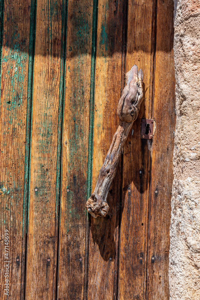 Poignée de porte en cep de vigne sur une maisonnette ancienne dans un petit village vigneron dans le puy de dôme Poignée de porte en cep de vigne sur une maisonnette ancienne dans un petit village vigneron dans le puy de dôme