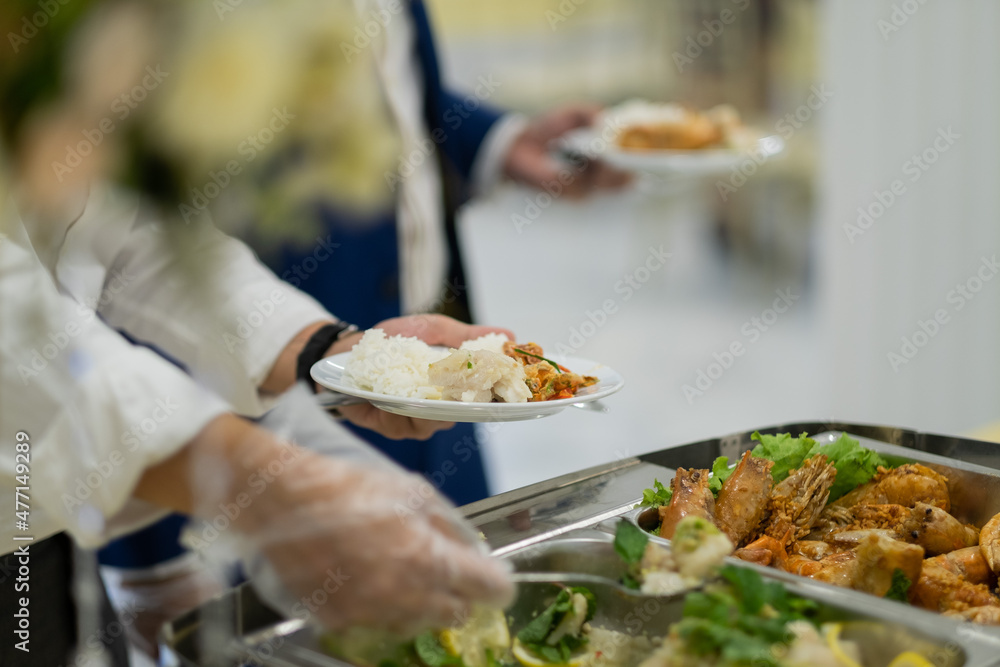 a person wearing gloves scooping food, catering, dinner time, prevent Coronavirus disease (covid 19) a person wearing gloves scooping food, catering, dinner time, prevent Coronavirus disease (covid 19)