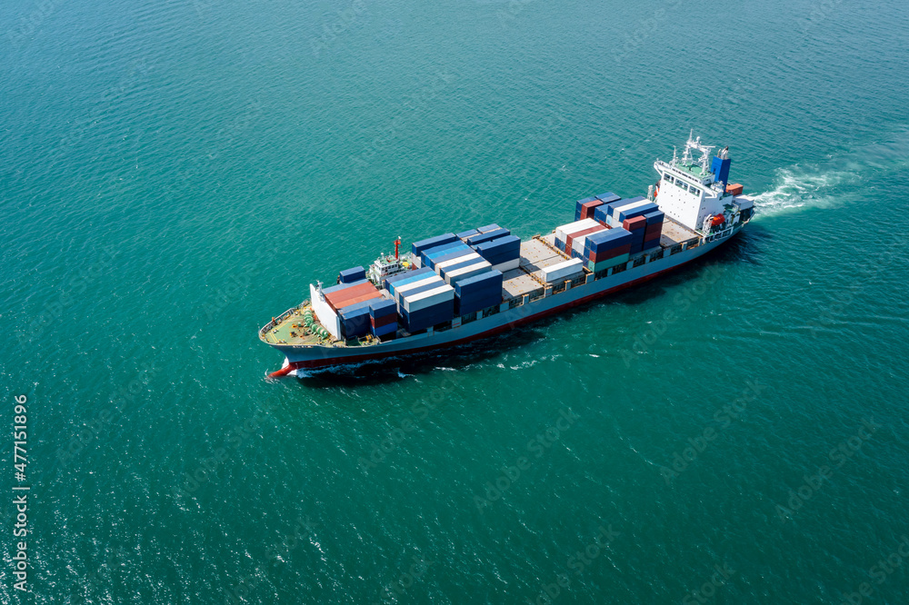 angle view in front container ship full speed in green sea, business and industry transportation import export international by container ship open sea horizon and blue sky background