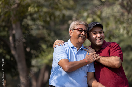 Cheerful grandfather spending leisure time with son at park 