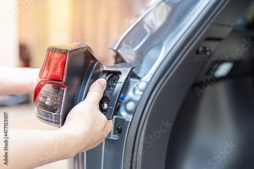 Foto Close up hand a man holding car tail lights are being assembled with the car bod