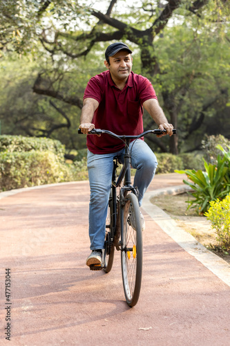 Cheerful man riding bicycle at park
