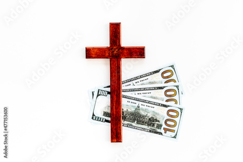 Money and religion. Wooden cross on dollars