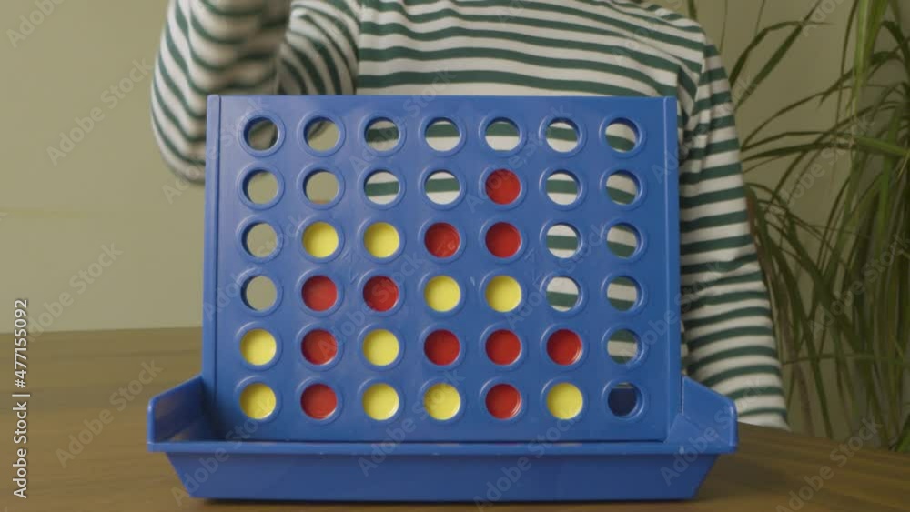 Child Playing and Winning Four in a Row Game. 