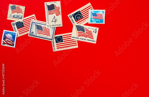 American flag postage stamps against red background