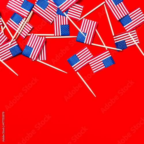 Small American flag toothpicks on red background photo