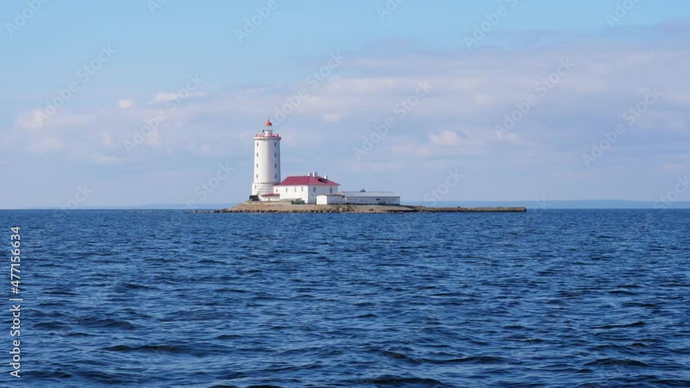 Tolbukhin lighthouse near Kronstadt island, view from boat in summer day. Historical buildings at artificial island. Inhabited place with only personnel (lighthouse keeper) living in two-storey home Tolbukhin lighthouse near Kronstadt island, view from boat in summer day. Historical buildings at artificial island. Inhabited place with only personnel (lighthouse keeper) living in two-storey home