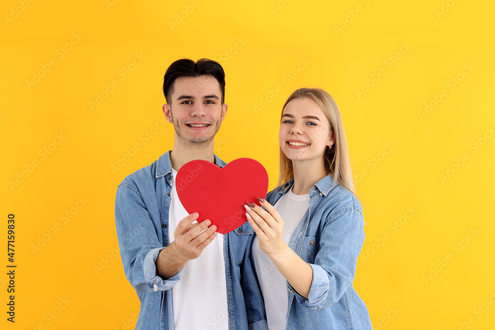 Cute couple with heart on yellow background Cute couple with heart on yellow background