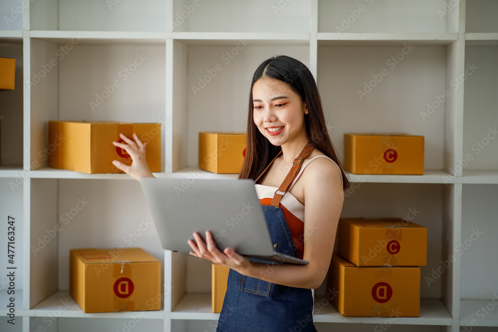 Startup small business entrepreneur SME or freelance woman using a laptop with box, AsianYoung woman seller prepare parcel box of product for delivery to customer Online selling e-commerce SME concept Startup small business entrepreneur SME or freelance woman using a laptop with box, AsianYoung woman seller prepare parcel box of product for delivery to customer Online selling e-commerce SME concept