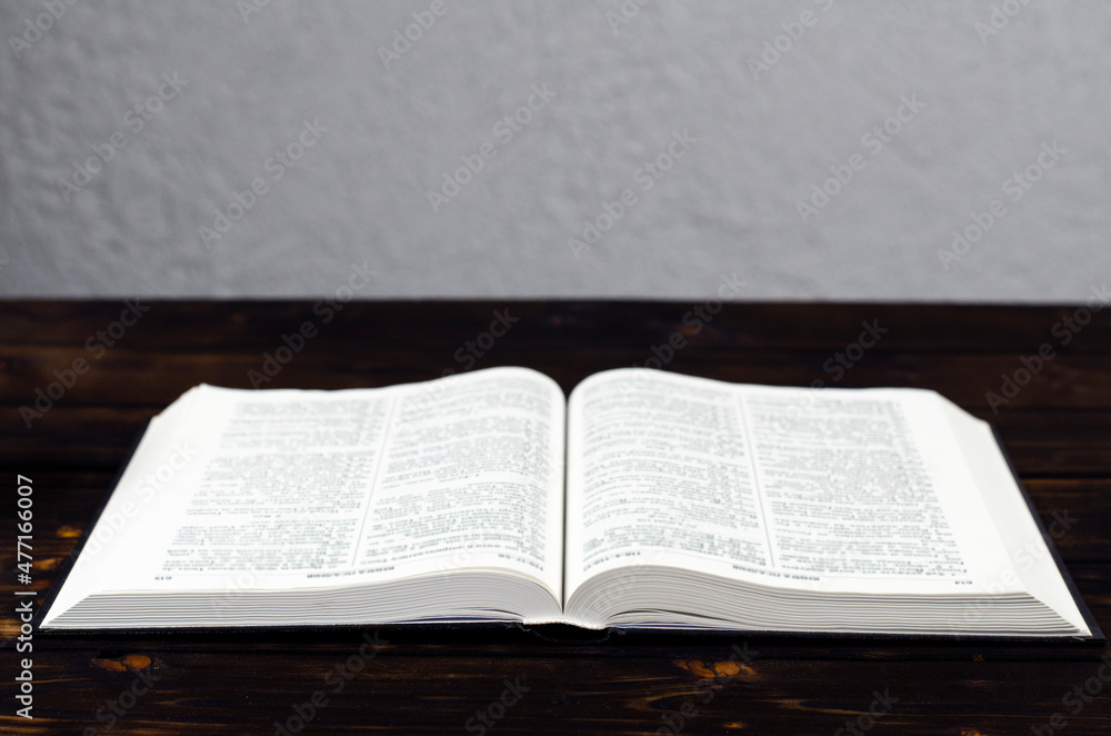 Open Bible, on a wooden table. Light from the book. Desktop. Open Bible, on a wooden table. Light from the book. Desktop.