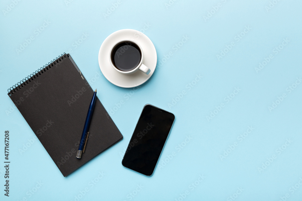 Modern office desk table with notebook, smartphone and other supplies with cup of coffee. Blank notebook page for you design. Top view, flat lay Modern office desk table with notebook, smartphone and other supplies with cup of coffee. Blank notebook page for you design. Top view, flat lay