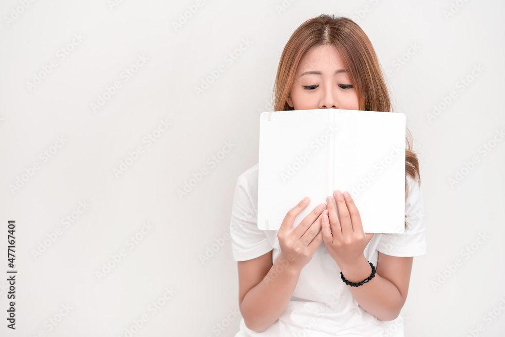 Young attractive asian student holding books in her arm on white background. School girl with a books to read for homework. Young attractive asian student holding books in her arm on white background. School girl with a books to read for homework.
