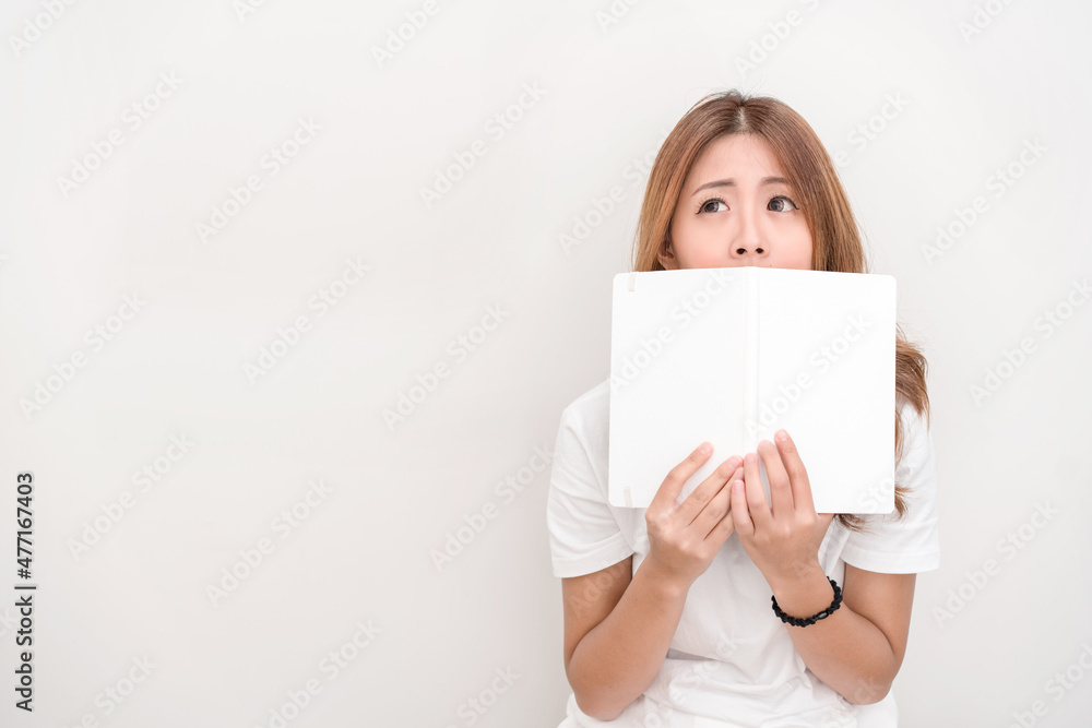 Young attractive asian student holding books in her arm on white background. School girl with a books to read for homework. Young attractive asian student holding books in her arm on white background. School girl with a books to read for homework.