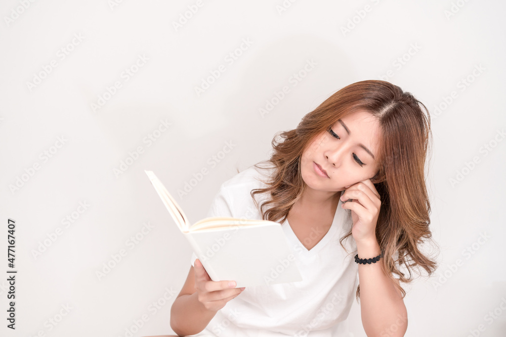 Young attractive asian student holding books in her arm on white background. School girl with a books to read for homework. Young attractive asian student holding books in her arm on white background. School girl with a books to read for homework.