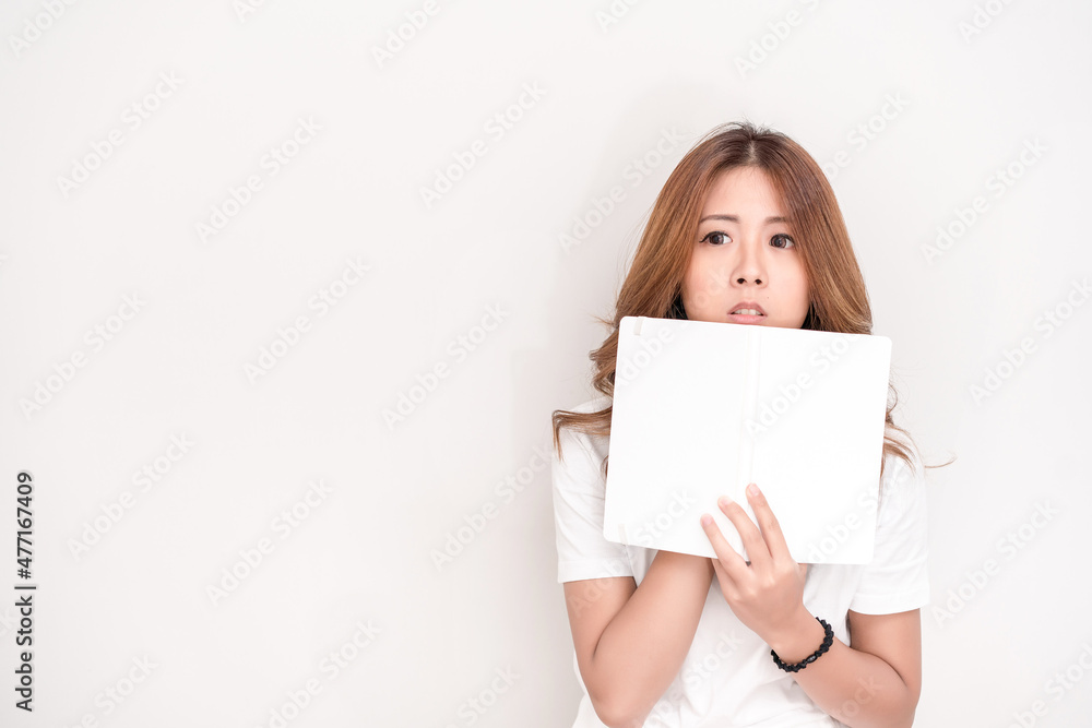 Young attractive asian student holding books in her arm on white background. School girl with a books to read for homework.