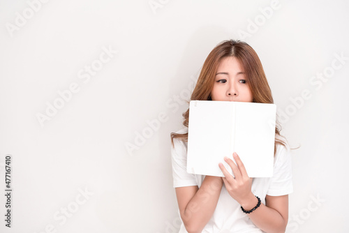 Young attractive asian student holding books in her arm on white background. School girl with a books to read for homework.
