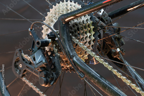 mountain bike in the workshop. Bicycle rear derailleur close-up on a black background. The concept of cycling improves health and mood.