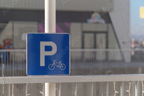 Close-up shot of a bicycle parking sign attached to a metal fence