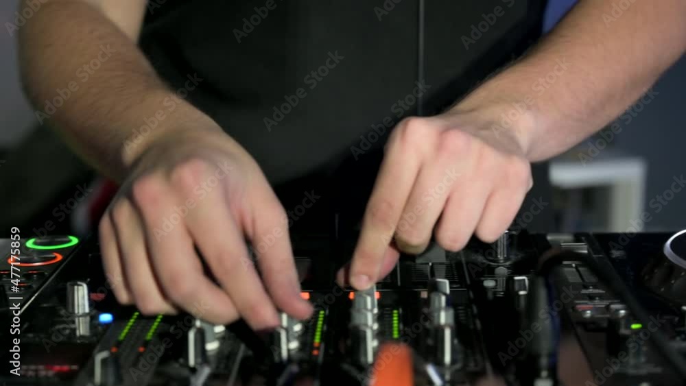 Tracking shot of a Man DJ playing with mixer and digital turntables. CDJ turntables with wires, button and sliders being played by electronic music Disc Jockey at nightclub. High quality 4k footage Tracking shot of a Man DJ playing with mixer and digital turntables. CDJ turntables with wires, button and sliders being played by electronic music Disc Jockey at nightclub. High quality 4k footage