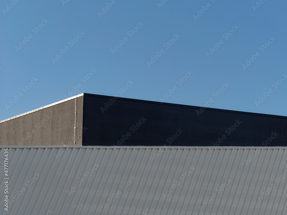 Daylight shot of a roof of a  modern building with a blue sky in the background