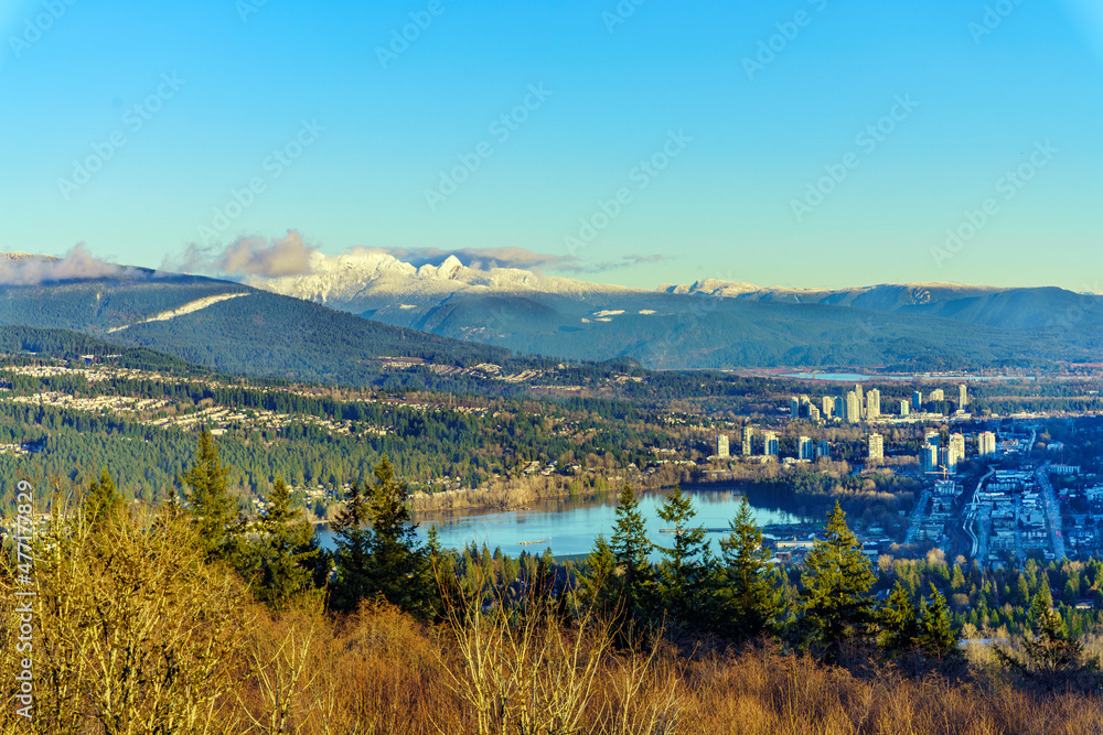 Scenic aerial view of Burrard Inlet at Port Moody, BC, on a clear winter day, with mountain backdrop.