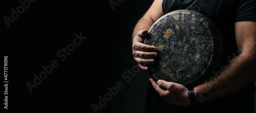 craftsmanship hands have a typical Italian cheese. French tomme cheese in the hands of a cheesemaker on dark background. Long banner format