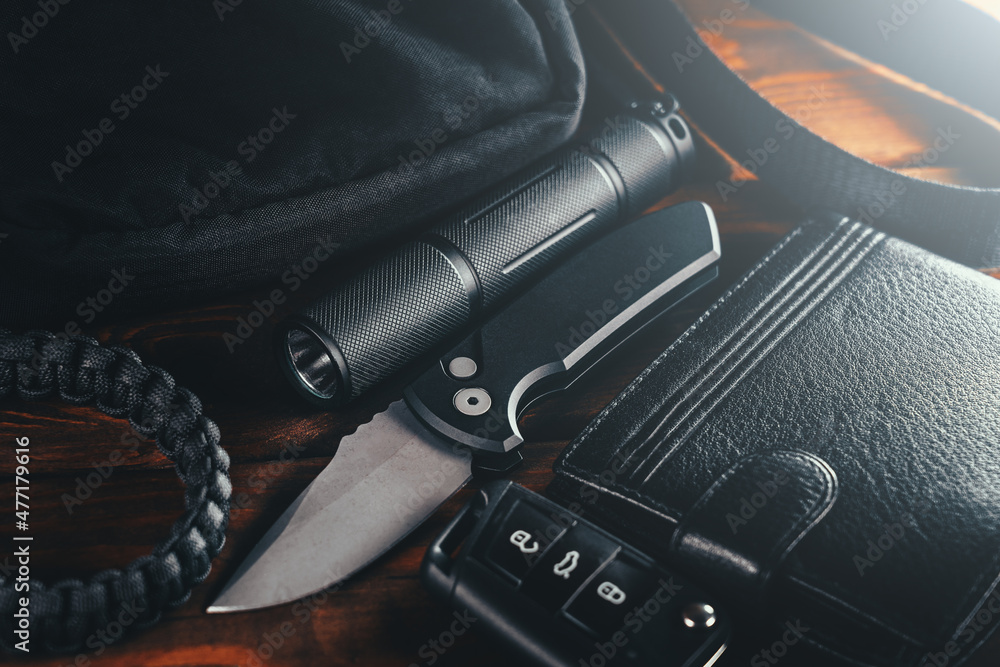 EDC set. Items for Everyday Carry use. Automatic Knife, car keys, paracord  bracelet, wallet and tactical bag. Accessories in urban military style for  man. Stock Photo