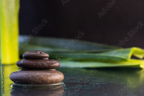 Fototapeta Naklejka Na Ścianę i Meble -  Zen stones with water on black background with leaves
