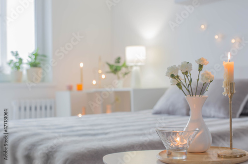 white flowers in vase on table in bedroom