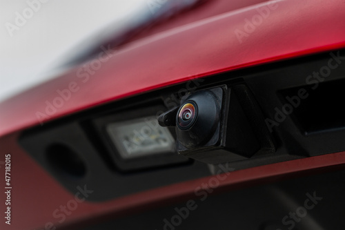 Close up view of rear view parking assist video camera on the car. Modern rear view cameara on modern car trunk. Parking assistant system. © Roman
