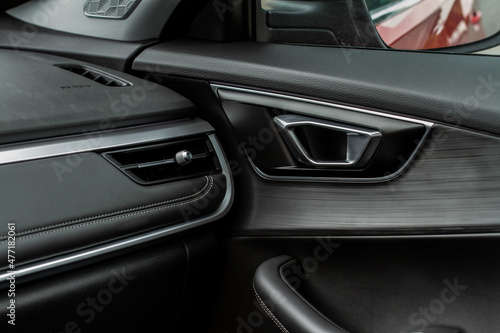 Modern car interior door handle close up. Metallic Car door opener handle inside. © Roman