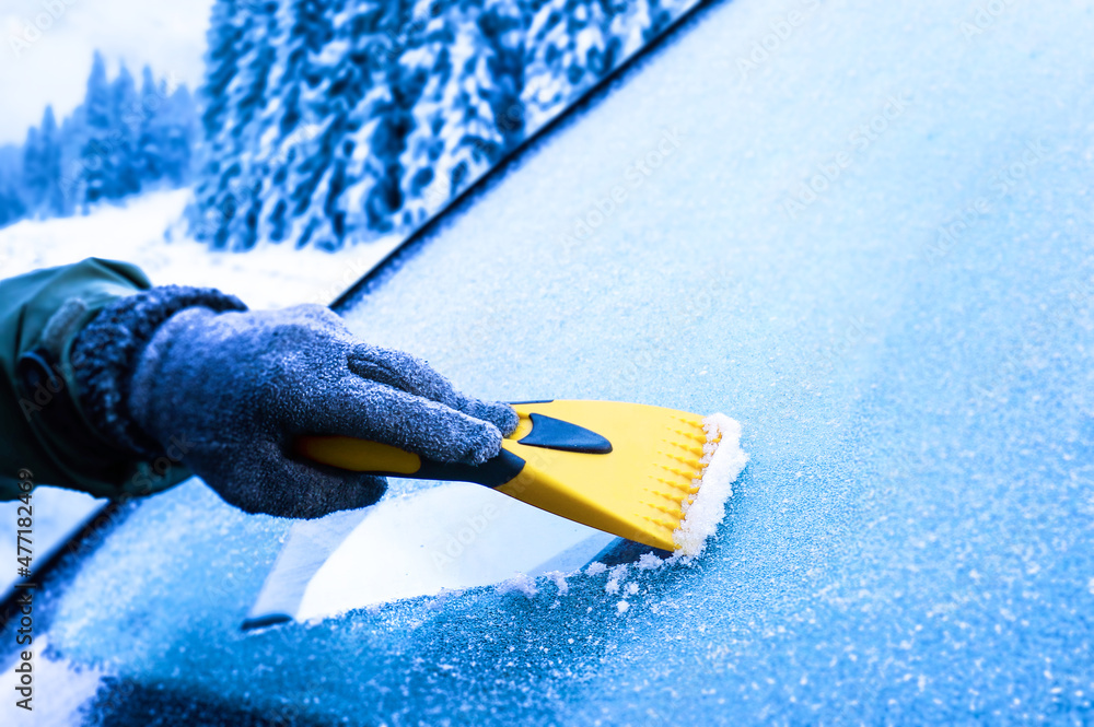 Clearing and remove snow from windshield, Scraping ice. Winter season car window cleaning. Copy space for your text. Panoramatic banner. - obrazy, fototapety, plakaty 