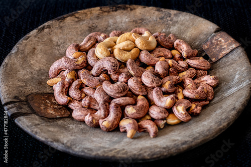 Many cashews in the old rustic wooden bowl