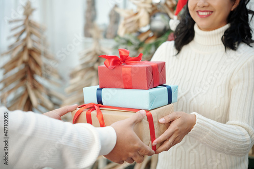 Smiling woman accepting Christmas presents from husband