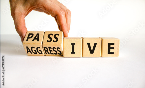 Passive or aggressive symbol. Businessman turns wooden cubes and changes the word passive to aggressive. Beautiful white background, copy space. Business, psychological passive aggressive concept. photo
