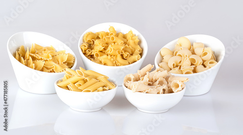 Pasta in a white bowl, isolated on a white background with reflection.